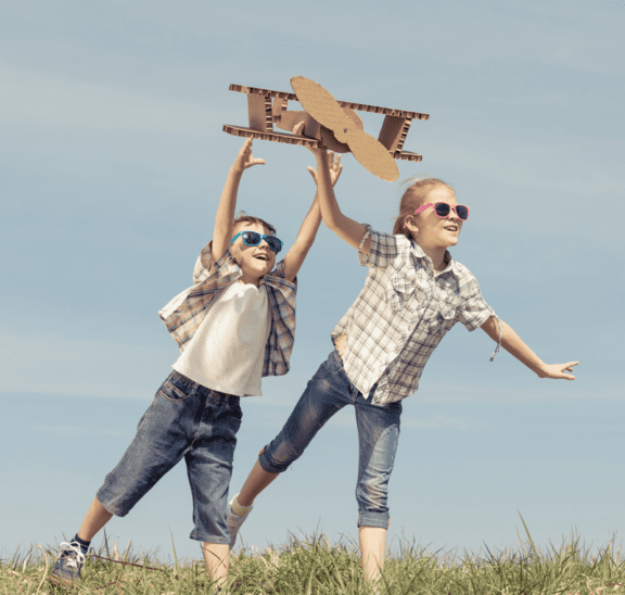 Power of fun with kids flying cardboard aeroplane