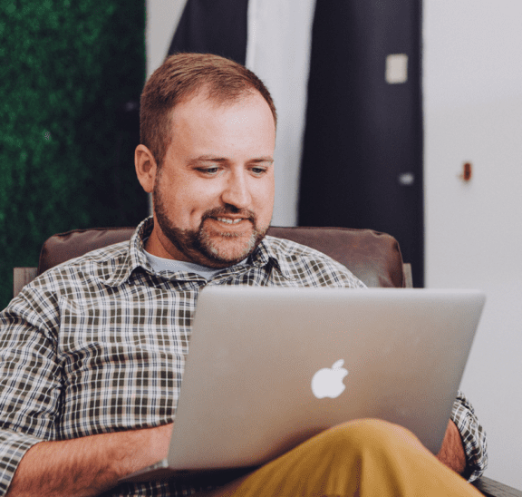 Man using laptop at home playing virtual trust building activities