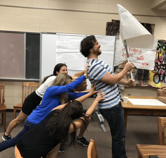 Teachers holding flag working to set behavioural norms